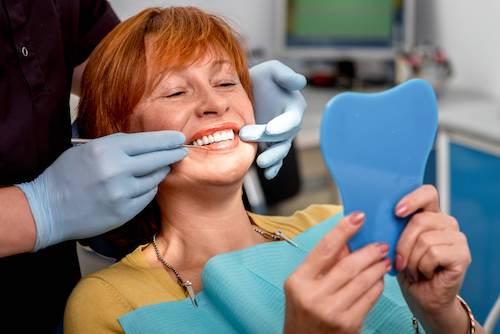 woman with red hair smiling in dentist exam chair | marysville wa dentist