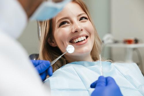 A smiling woman receiving a dental exam | dentist marysville wa