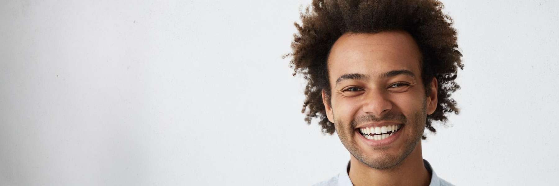 A smiling man in front of a white background