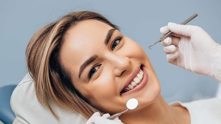 A smiling woman getting a dental exam and tooth extraction in Marysville, WA