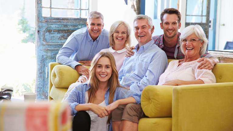 A smiling family posing in the living room