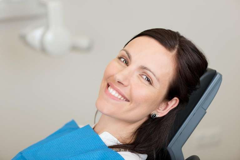 woman sitting in dental exam chair | facial aesthetic treatments marysville