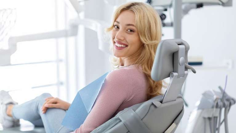 woman sitting in exam chair smiling | marysville dentist