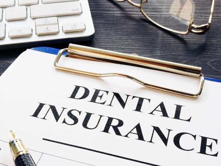 A clipboard reading dental insurance | cosmetic dentist marysville wa